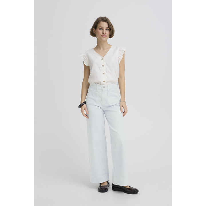 Woman wearing a white blouse and light blue jeans on a white background